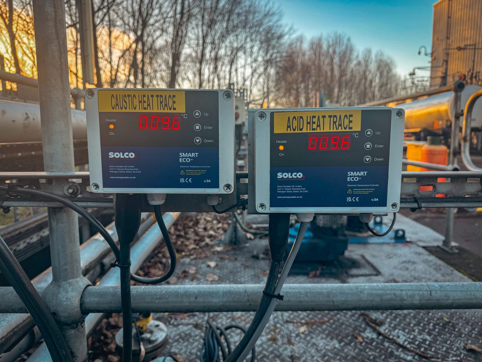 Solco Smart Eco heat trace controllers showing caustic and acid pipe temperatures at a chemical manufacturing plant